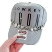 Lowkey Icon Silver Charm Trucker Hat